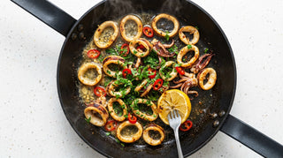 Seared calamari with chilli, garlic and parsley in a black pan